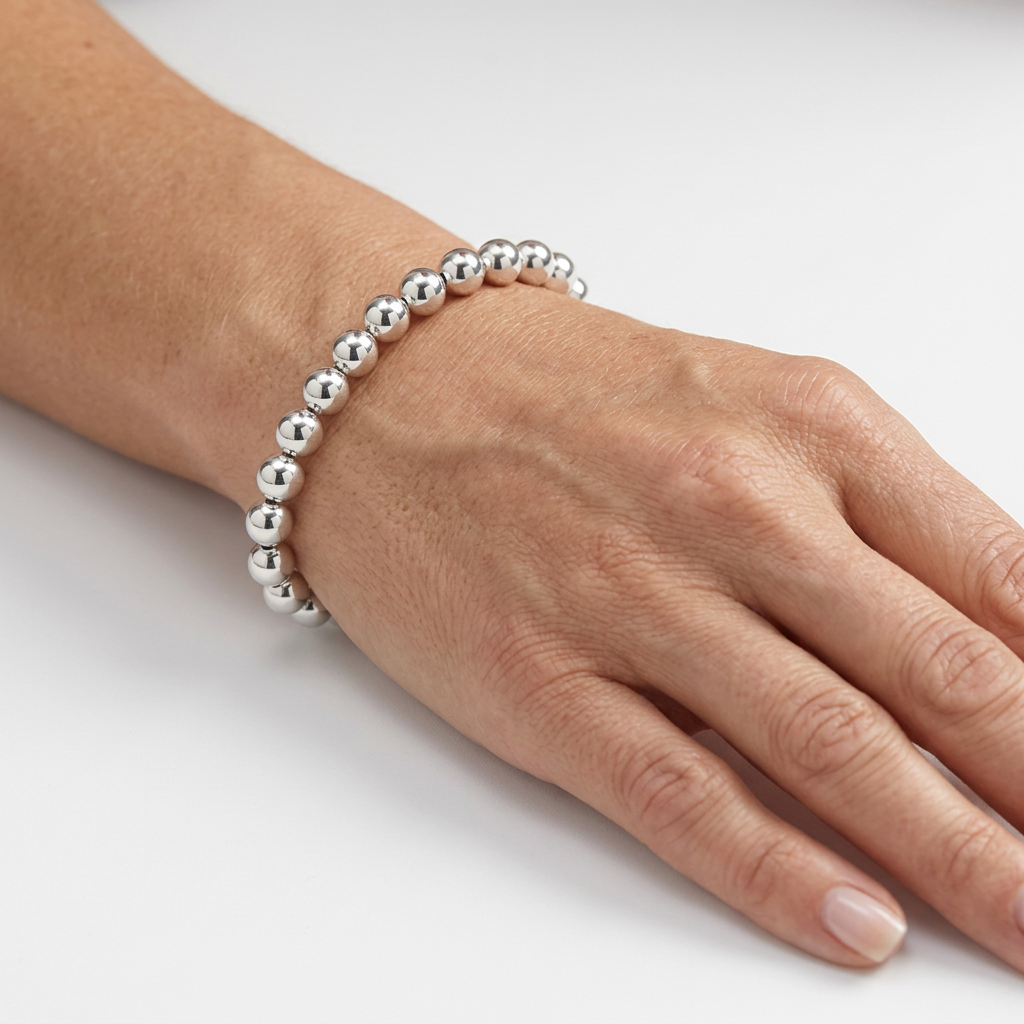 Silver beaded bracelet on a hand model’s wrist