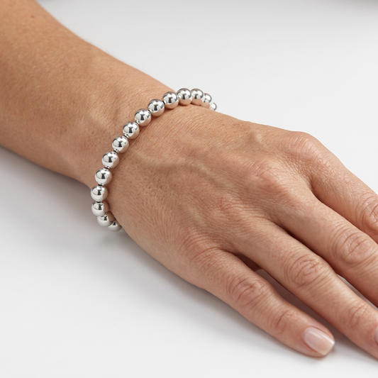 Silver beaded bracelet on a hand model’s wrist